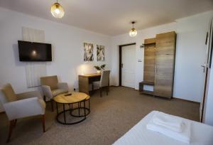 a living room with a table and a desk at Hotel Lubaczów Hotel Restauracja u Dina in Lubaczów