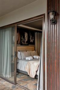 a bed in a room with a glass door with a bed sqor at RiverBanks in Wilderness