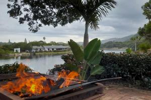 a fire pit in front of a body of water at RiverBanks in Wilderness