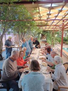 a group of people sitting at a long table eating at North Jewel 2023 in Ajloun