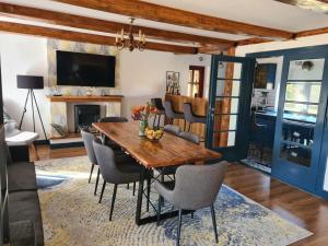 ein Esszimmer mit einem Holztisch und Stühlen in der Unterkunft Vama Buzaului Hillside Barn - camere la munte in Vama Buzăului