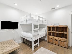 a white bunk bed in a room with a tv at CaSEAta by 30A Escapes in Rosemary Beach