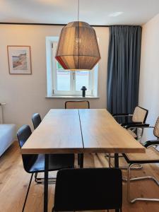 ein Esszimmer mit einem Holztisch und Stühlen in der Unterkunft TheBlueInn in Wasserburg am Inn