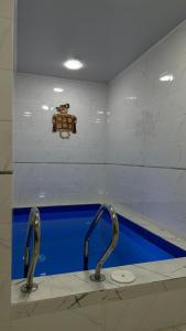 a bathroom with two faucets and a blue sink at Klass in Taraz