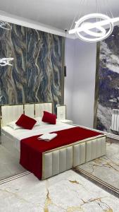 a bedroom with a large bed with red pillows at Klass in Taraz
