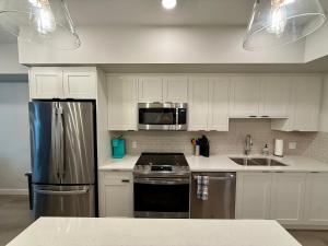 a kitchen with white cabinets and stainless steel appliances at Sparrowhawk Mountain Resort in Dead Man's Flats