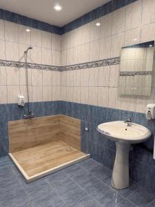 a bathroom with a shower and a sink and a tub at Balkan Hostel in Tirana +66 photos