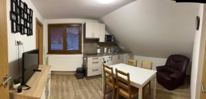 a kitchen with a table and a dining room at Apartmány TAS in Jablonec nad Jizerou