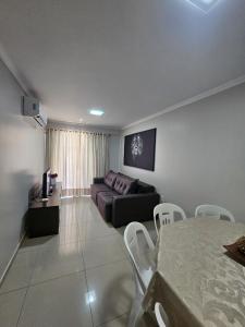 a living room with a couch and a table at Apartamento 3 Quartos - Centro de Piratuba in Piratuba