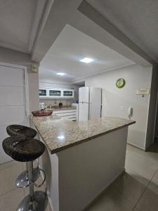 a kitchen with a counter and a refrigerator at Apartamento 3 Quartos - Centro de Piratuba in Piratuba +11 photos