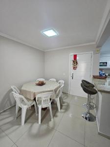 a white dining room with a table and chairs at Apartamento 3 Quartos - Centro de Piratuba in Piratuba