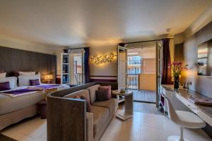 a hotel room with a bed and a couch at Hôtel de Paris Saint-Tropez in Saint-Tropez