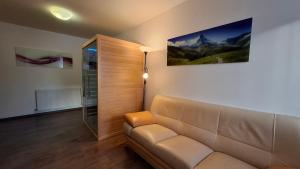 a living room with a couch and a painting on the wall at Apartmány u náměstí Sušice in Sušice