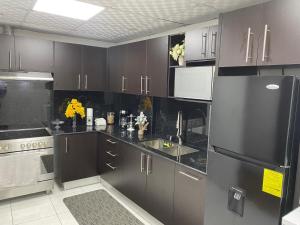 a kitchen with brown cabinets and a stainless steel refrigerator at Residencial Lassonde Guest House in David