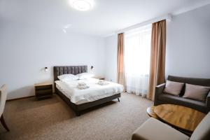 a hotel room with a bed and a couch at Hotel Lubaczów Hotel Restauracja u Dina in Lubaczów