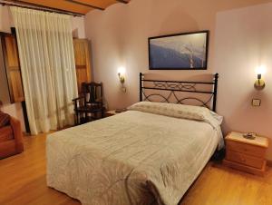 a bedroom with a large bed and a chair at La Artesana in Posada de Rengos