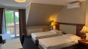 a hotel room with two beds and a balcony at Hotel Zajazd Polonez in Tuczempy +40 photos