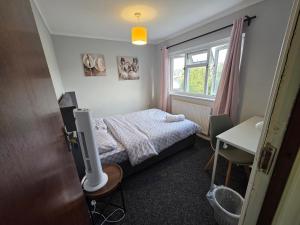 a small bedroom with a bed and a window at Fenia Estate in Barking