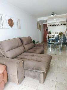 a living room with a couch and a dining room at Apartamento Completo I Suíte Casal in Guarapari