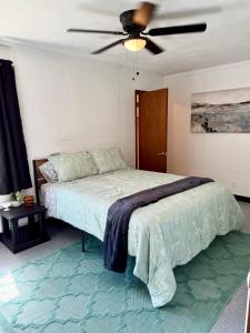 a bedroom with a bed with a ceiling fan at 4th Street Residences in Saint David
