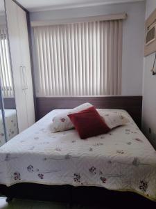 a bed with two pillows on it in a bedroom at Apartamento Completo I Suíte Casal in Guarapari