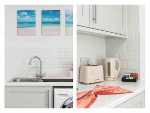 a kitchen with white cabinets and a sink and a counter top at Ferry Fab Pad By My Getaways in Brighton & Hove