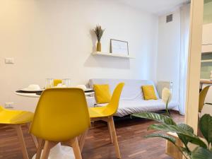 a dining room with a table and yellow chairs at Luxury Studio con Private Jacuzzi, Spa Experience in Perugia +15 photos