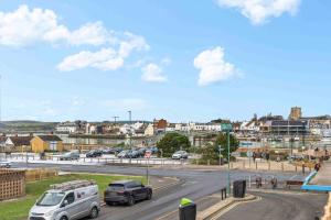 a city with cars driving down a road at Ferry Fab Pad By My Getaways in Brighton & Hove