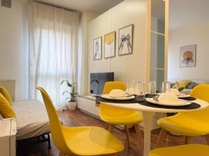 a dining room with a table and yellow chairs at Luxury Studio con Private Jacuzzi, Spa Experience in Perugia