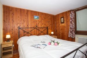 a bedroom with a large white bed with flowers on it at Casa di Maen in Valtournenche