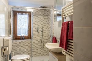 a bathroom with a sink and a toilet and a window at Casa di Maen in Valtournenche