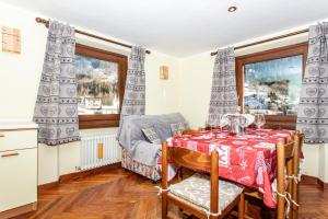 a dining room with a table and a chair and window at Casa di Maen in Valtournenche