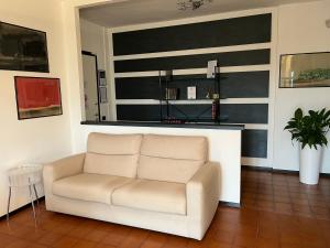 a white chair in a room with a wall with stripes at MaMà - Ma Maison d'Hotes in Vigliano Biellese +16 photos