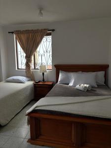 ein Schlafzimmer mit zwei Betten und einem Fenster in der Unterkunft Hotel Tahami in Sonsón