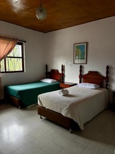 ein Schlafzimmer mit zwei Betten und einem Fenster in der Unterkunft Hotel Tahami in Sonsón