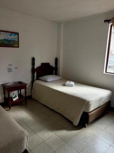 ein Schlafzimmer mit einem großen Bett und einem Tisch in der Unterkunft Hotel Tahami in Sonsón + 11 Fotos