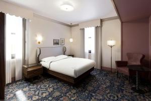 a hotel room with a bed and a chair at The Queen’s Cue, Stratford, A Tribute Portfolio Hotel in Stratford +10 photos