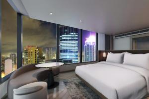 a bedroom with a bed and a view of a city at AC Hotel by Marriott Manila in Manila +49 photos