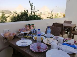 a table with plates of food and water bottles at Farida Pyramid Boutique Hotel in Cairo