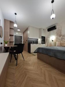 a bedroom with a bed and a table and a kitchen at Apartamenty Skalny Loft in Karpacz