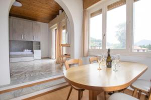 a kitchen and dining room with a wooden table and chairs at Villa Laura in Germignaga