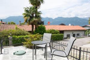 a patio with two chairs and a table and a fence at Villa Laura in Germignaga