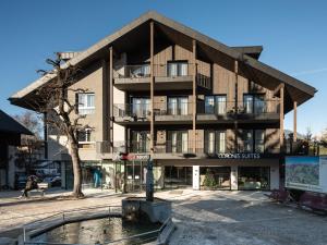 an apartment building with a fountain in front of it at Corones Suites - Dolomites Residence in Valdaora