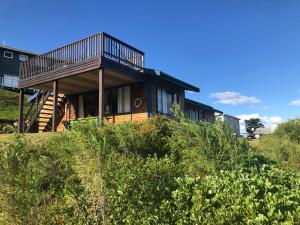 a house with a deck on top of a hill at Emma's Beach Cottage in Great Brak River