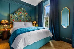 a blue bedroom with a bed and a window at Hestia House in Derry Londonderry