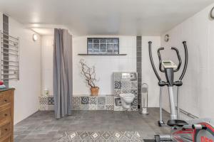 a bathroom with a gym with a toilet and a treadmill at Cosy stay in southern Malmo in Malmö