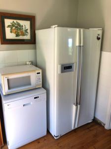 a white refrigerator and a microwave in a kitchen at Emma's Beach Cottage in Great Brak River