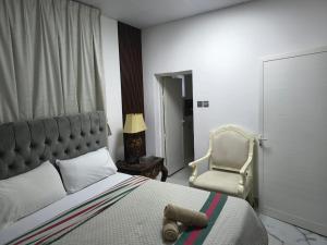 a bedroom with a large bed and a chair at Villa Laila in Sabkhah