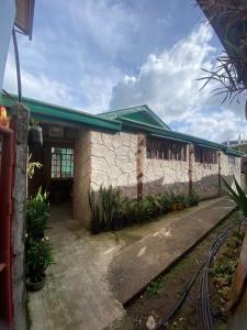 a building with a stone wall next to a train station at Acai's Transient House in Sagada +16 photos