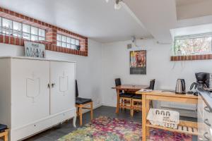 a kitchen with white cabinets and a desk and a table at Cosy stay in southern Malmo in Malmö